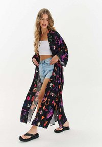 Černý kimono s barevnými květinovými a zvířecími vzory, otevřený přední díl, dlouhé rukávy a lehká tkanina. Nosič přes crop top a šortky.