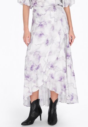 Mellem-lang hvid nederdel med lilla blomsterprint kombineret med sorte ankelstøvler med spids tå og hæl på en model.