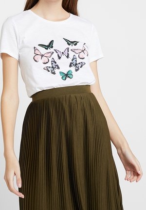 Camisa blanca de manga corta con estampados de mariposas multicolores combinada con una falda midi plisada de color verde oliva en una persona.