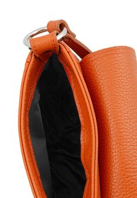 Orange textured leather bag with a silver ring handle, showing an open top with black fabric lining inside.