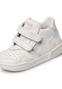Sneaker bianca in pelle con punta perforata, due fasce in Velcro e accenti a pois pastello. Suola in gomma testurizzata. Marchio "Falcotto" visibile.
