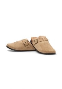 Zuecos de ante beige con un suave forro de piel, que cuentan con dos correas ajustables con hebillas de metal y una suela de goma negra texturizada.