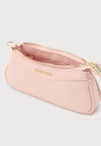 Kis, puha rózsaszín Valentino bőr tartó arany cipzárral és logóval, részben nyitva, bemutatva a belső cipzáras zsebet és az arany fémgyűrűt.