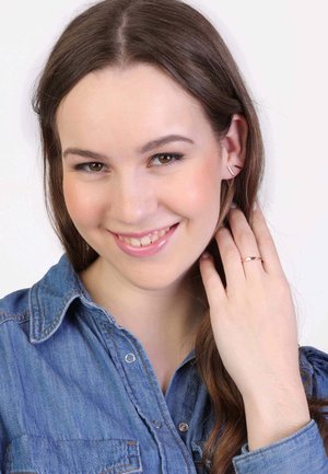 Roze gouden ring en oorcuff met een vrouw in een denim shirt. De oorcuffs hebben lineaire ontwerpen die de algehele uitstraling verbeteren.