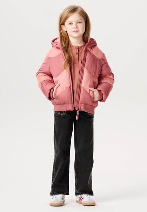 Roze pufferjack met diagonale panelen, twee voorzakken en een capuchon, gecombineerd met zwarte flared jeans en witte sneakers.