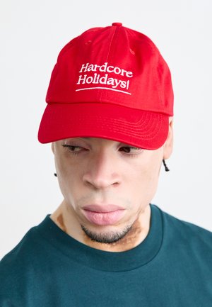 Rote Baumwoll-Baseballmütze mit gesticktem weißen Text "Hardcore Holidays!" auf der Vorderseite. Verfügt über einen gebogenen Schirm und einen verstellbaren Rücken.