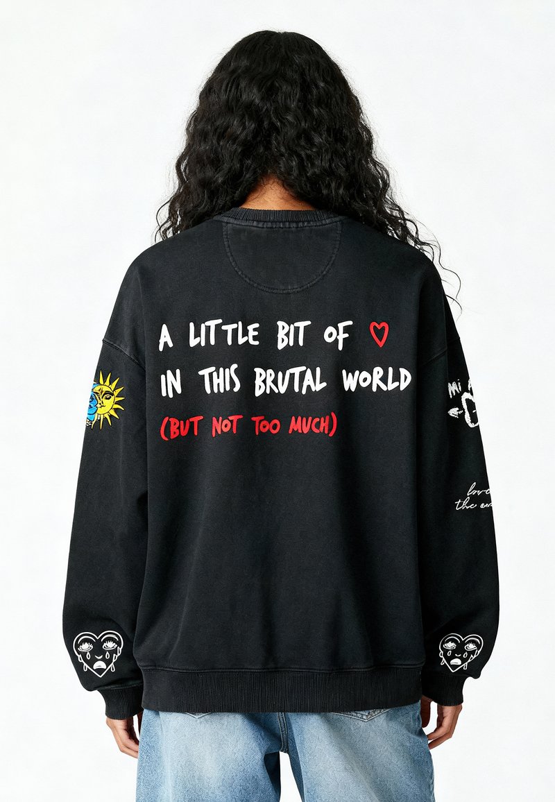 Felpa nera oversize con grafiche colorate sul retro e sulle maniche, inclusi testi e design a cuore con una texture vissuta.