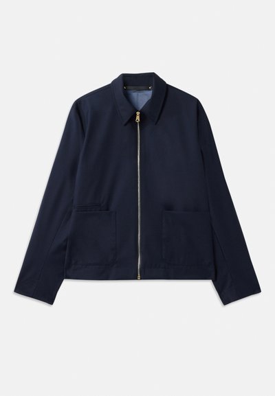 Giacca blu navy con chiusura zip, colletto a punta e due tasche frontali. Tessuto liscio con un design su misura e corto. Dettagli in hardware dorato.