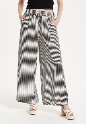 Wide-leg trousers in black and white vertical stripes. Made of a lightweight fabric with an elastic waistband and side pockets.