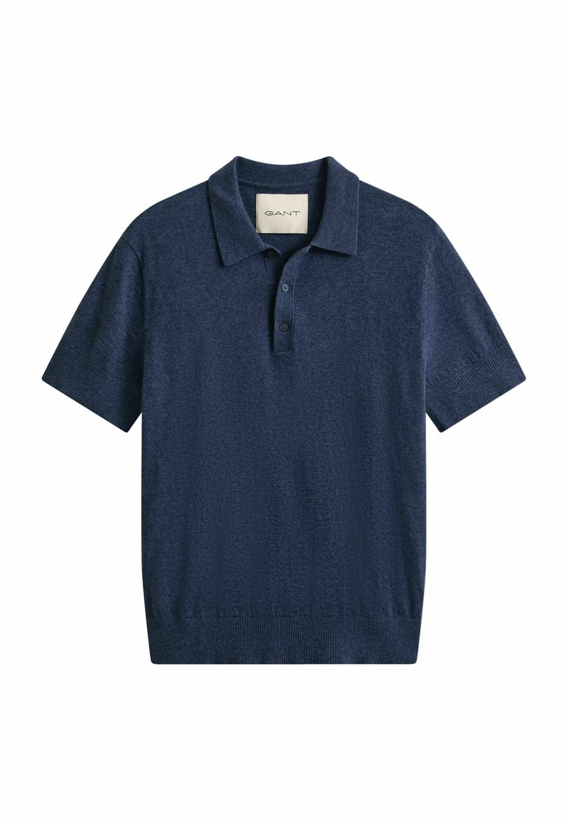 Polo bleu marine à manches courtes avec col, patte à deux boutons, poignets côtelés et étiquette de la marque GANT à l'intérieur du col.