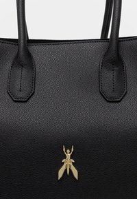 Borsa a mano in pelle nera con trama, dotata di due manici, con un logo a forma di insetto dorato sul fronte.