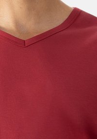Rode katoen T-shirt met een V-hals ontwerp, met een gladde textuur en een getailleerde vorm. Geen patronen of extra details aanwezig.