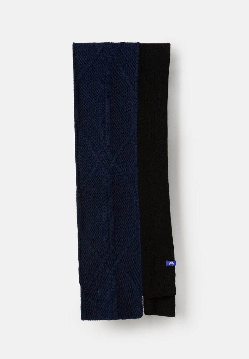 Navy blue cable-knit scarf folded next to solid black scarf, both lying flat on white background, with small blue brand tag visible.