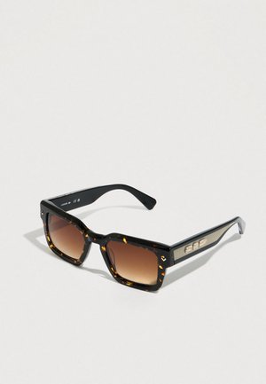 Ochelari de soare dreptunghiulari cu rame de culoarea scoicii de testoasa, lentile gradient maro și brațe negre cu detalii dungi aurii și plăcuță cu logo.