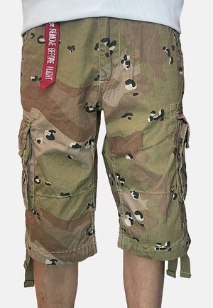 Camouflage cargo shorts with side pockets and a red "Remove Before Flight" tag hanging from the waistband.