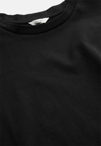 Svart t-shirt med rund hals made of smooth fabric med en synlig etikett som läser "CELLBES of Sweden" sydd inuti kragen.