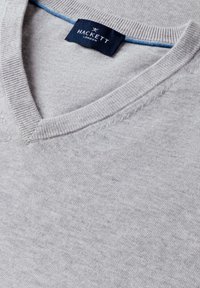 Pull gris clair à encolure en V avec col côtelé et étiquette Hackett London bleu marine cousue à l'intérieur du col.