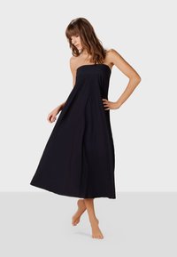 Svart strapless maxiklänning med en flödande silhuett, tillverkad av ett lätt tyg, med en mjuk textur och ankellång design.