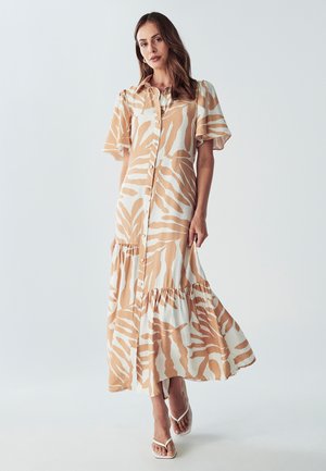 Long button-up dress in cream with brown zebra stripes, short flutter sleeves, and tiered skirt. Made of lightweight fabric, ankle-length.