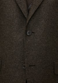 Brauner Wollblazer mit strukturiertem Finish, zwei Knöpfen und Taschen an den Seiten. Verfügt über einen Reverskragen und dezente Stickdetails.