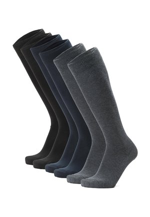 Zeven paar kniehoge sokken naast elkaar gerangschikt, in zwart, donkerblauw en donkergrijs.
