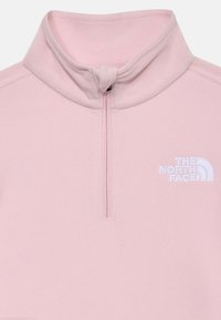 Ανοιχτό ροζ fleece πουλόβερ με μισό φερμουάρ, διαθέτει ψηλό γιακά και κεντημένο λευκό λογότυπο στο στήθος. Λείο υλικό.