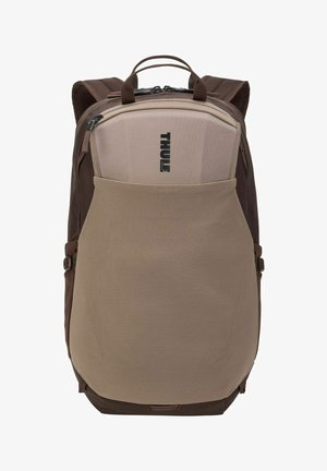 Bruine en beige Thule-rugzak met gewatteerde schouderbanden, voorvak van gaas en dubbele bovenhandvatten, van voren gezien.