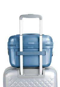 Maleta rígida azul de tamaño cabina con un diseño texturizado, apilada sobre una maleta plateada, que cuenta con un mango de metal extensible.