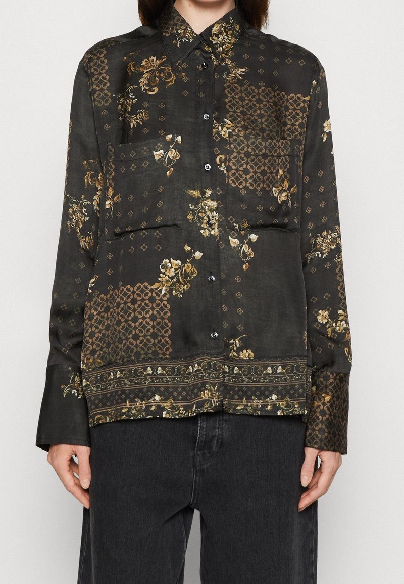 Camicia nera con motivo floreale e geometrico, caratterizzata da bottone frontale, maniche lunghe e una texture morbida.