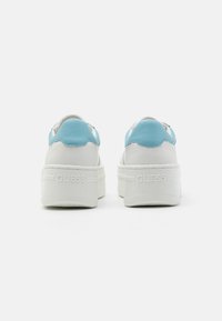 Sneaker bianchi con dettagli azzurri. Parte superiore in pelle con design testurizzato. Presenta un marchio sul tallone e una suola bianca spessa.