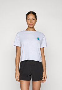 T-shirt court gris clair à manches courtes avec un logo tourbillon coloré sur la poitrine, associé à un short noir ample.