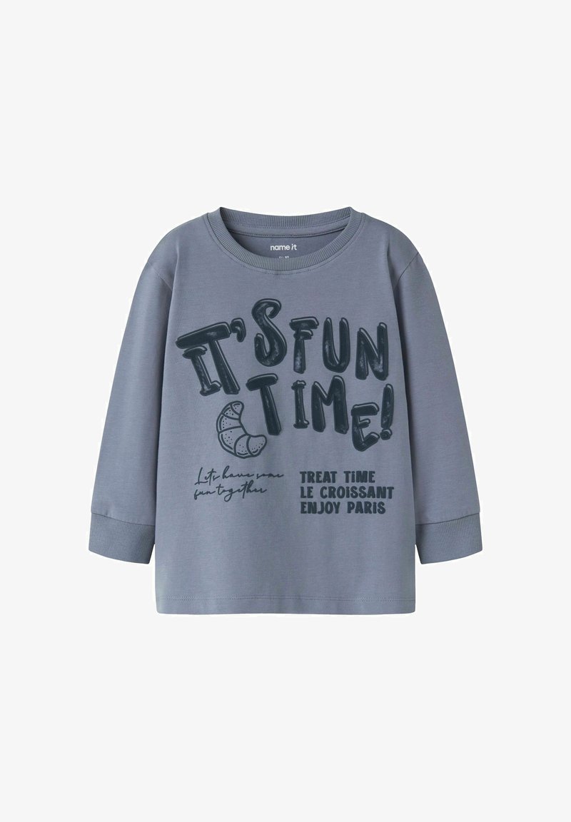 Graues Langarm-T-Shirt aus Baumwolle mit rundem Ausschnitt. Mit großem schwarzem Text: "ES IST SPASSZEIT!" und "LECKERZEIT, DER CROISSANT, GENIEßE PARIS."