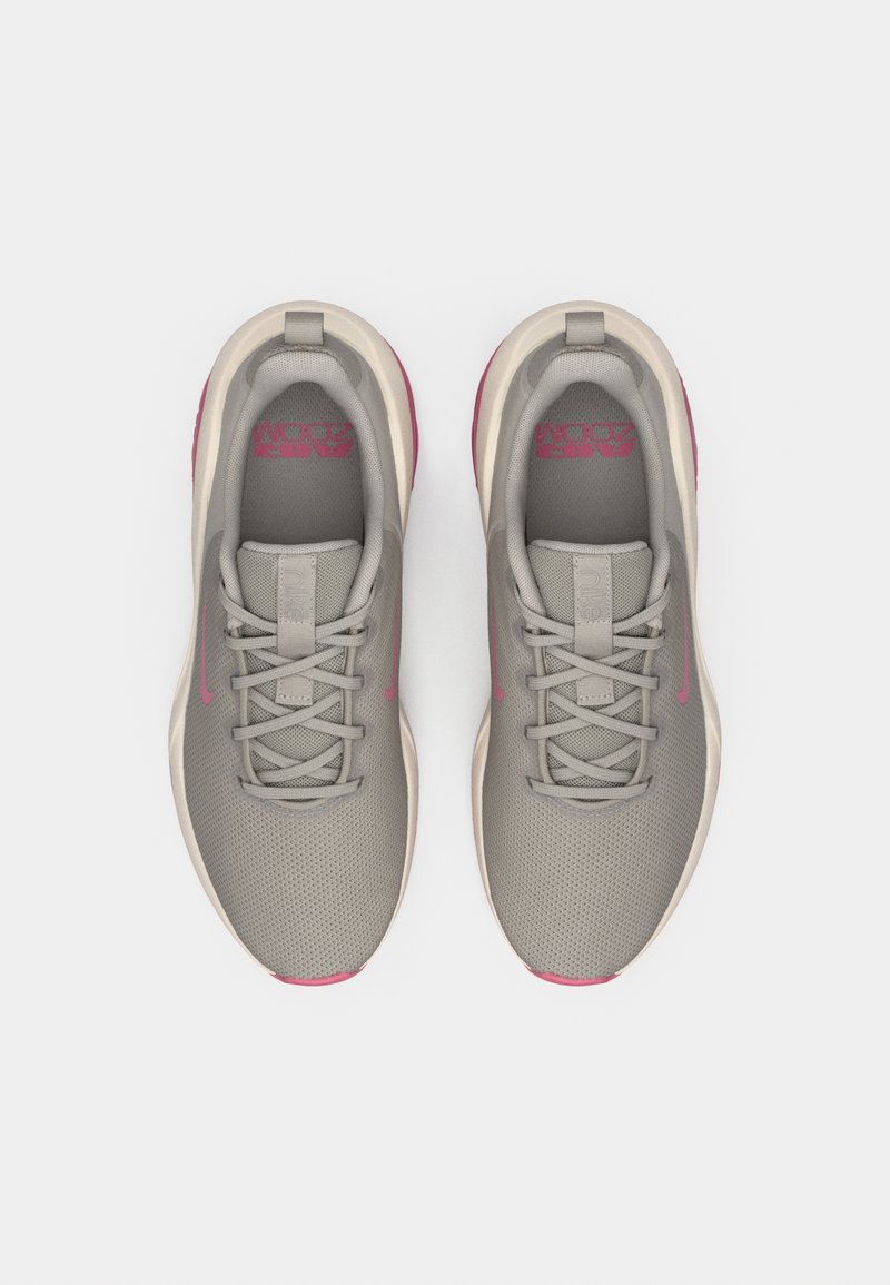 Gray athletic shoes with mesh upper, pink accents, and a cushioned sole. Features traditional lacing and branding on the tongue.