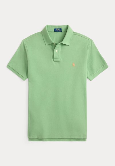 Gaiši zaļš īssvārku polo krekls ar apkakli, diviem pogu slēdžiem un mazu persiku krāsas izšūtu logotipu uz krūtīm.