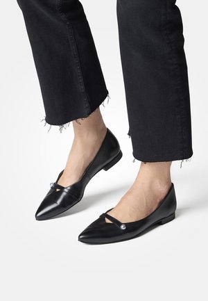 Sorte læderballerinaer med spids tå, udstyret med en dekorativ rem og perleaccent. Glat tekstur med et lavt profileret design.