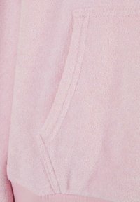 Lichtroze hoodie met een zachte terry structuur, een voorkwab en geribbelde mouwen, ontworpen voor comfort en casual gebruik.