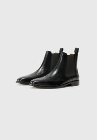 Botas Chelsea de cuero negro con paneles elásticos en los laterales, detalles de brogue a lo largo de la punta y un tacón bajo y cuadrado. Textura suave y forma puntiaguda.