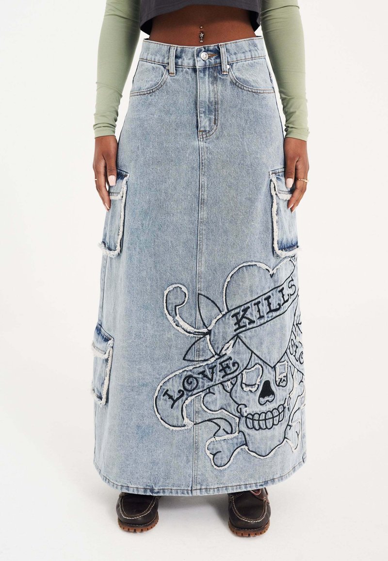 Lysblå denim maxi nederdel med frynset kanter, der har et stort broderet kranie og bannerdesign med teksten "LOVE KILLS."