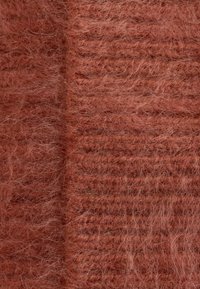 Textured, fluffy fabric in rust color, featuring a soft, fuzzy appearance with visible fibers and a horizontal ribbed pattern.