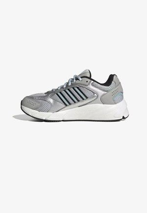 Grijze en zilveren sportschoen met zwarte accenten, mesh- en synthetisch bovenwerk, witte dempende zool en veterluiting, zijaanzicht.