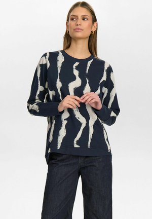 Felpa blu navale con motivo astratto a onde bianche, scollo a girocollo, maniche lunghe, vestibilità rilassata e orlo leggermente curvo.