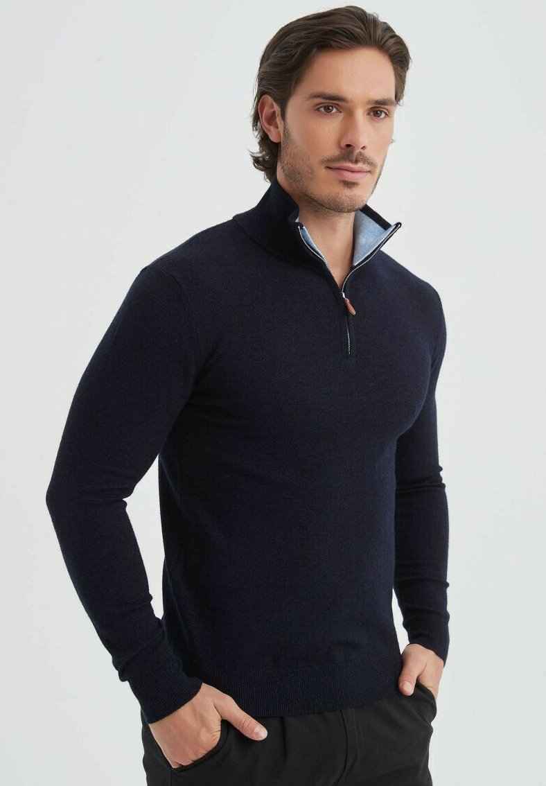 Pull-over navy avec col haut, fermeture éclair et doublure intérieure bleu clair. Design ajusté avec des poignets et un ourlet côtelés. Texture douce.