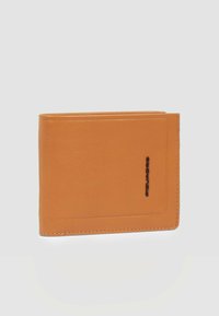 Cartera de cuero color canela con un acabado texturizado, diseño de doble pliegue y un logo negro en relieve en la parte frontal. La forma cerrada presenta bordes limpios.