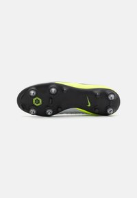 Nike fodboldstøvle, sort sål med gule detaljer, struktureret overdel, flere studs for greb, strømlinet design og logo detalje synlig.