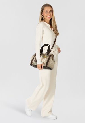 Hellebraune und braune Handtasche mit strukturiertem Design, die eine Materialmischung und ein dekoratives Muster aufweist. Akzente mit goldfarbenen Beschlägen.