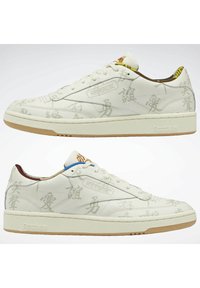 Baskets en cuir blanc avec des graphismes ton sur ton subtils, une semelle extérieure en caoutchouc gomme, et des accents multicolores sur la languette et le col.