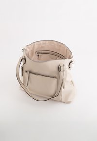 Sac à main en cuir beige avec un zip sur le dessus, une poche avant et un compartiment intérieur. Équipé de sangles ajustables et d'une surface texturée.