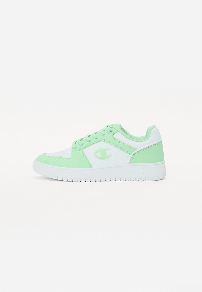 Scarpa sportiva bianca e verde menta. Presenta un materiale sintetico liscio, punta rotonda, suola piatta in gomma e dettaglio del logo sul lato.