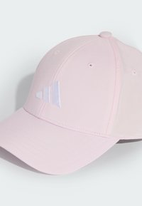 Růžová baseballová čepice z hladké látky. Má zakulacený kšilt a tři bílé pruhy vyšitý na předním panelu.