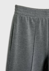 Gray athletic pants with elastic waistband, featuring side pockets and a soft, textured fabric. Simple design with no visible patterns.